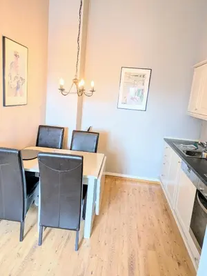 a kitchen and dining room with a table and chairs at Charming Top Floor Apartment With Balcony in Beitostøl
