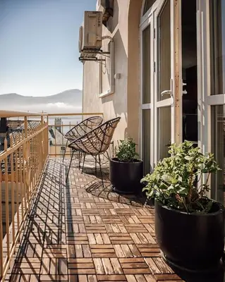 a patio with a chair and potted plants on a balcony at Fjord-view apartment in Ålesund