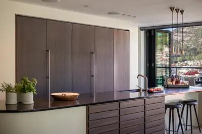 a kitchen with wooden cabinets and a counter with a sink at Nordnes Brygge in Bergen