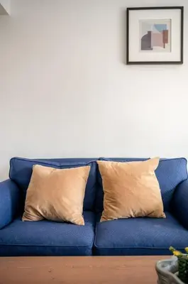 a blue couch with two pillows in a living room at Studio in the city centre in Trondheim