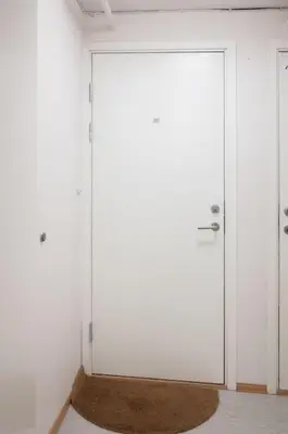 a large white door in a room with a rug at Studio in the city centre in Trondheim