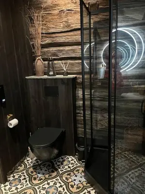 a bathroom with a toilet and a glass shower at Rudland Gård - Unik gårdsovernatting i stabbur fra 1750 in Sør-Fron