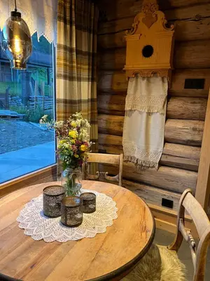 a wooden table with a vase of flowers on it at Rudland Gård - Unik gårdsovernatting i stabbur fra 1750 in Sør-Fron
