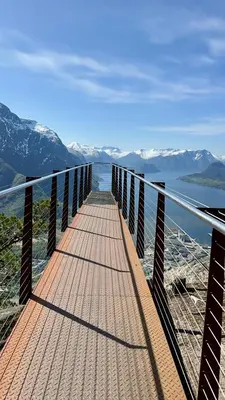 a bridge over a body of water with snow covered mountains at Villa Utsikten Eggen in Åndalsnes