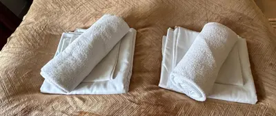 two white towels sitting on top of a bed at Villa Utsikten Eggen in Åndalsnes