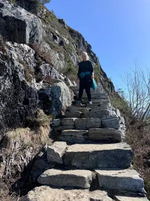 a man walking up a set of stone stairs on a mountain at Villa Utsikten Eggen in Åndalsnes