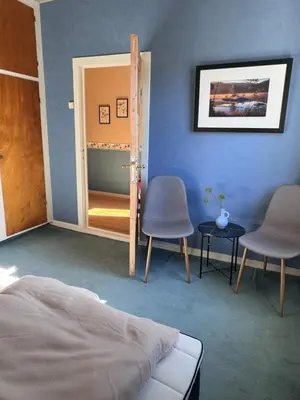 a bedroom with a door and two chairs and a mirror at Villa Utsikten Romsdalshorn in Åndalsnes