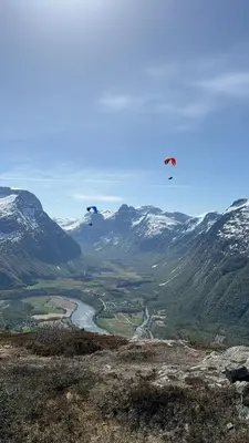 two kites flying over a valley with snow covered mountains at Villa Utsikten Romsdalen in Åndalsnes