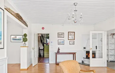 a living room with a fireplace and a chandelier at Doktorgarden in Selje