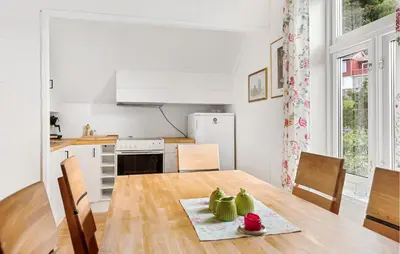 a kitchen and dining room with a wooden table at Doktorgarden in Selje