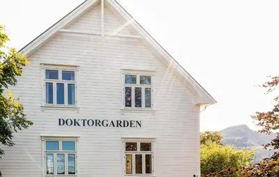 a white building with a sign that reads doomsday barn at Doktorgarden in Selje