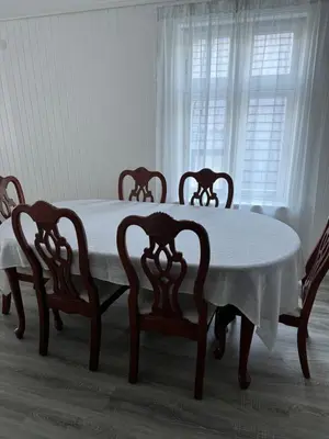 a table and four chairs with a white table and a window at Duży apartament w centrum in Ålesund