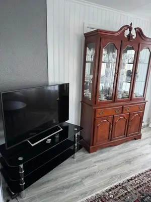 a wooden entertainment center next to a wooden cabinet at Duży apartament w centrum in Ålesund
