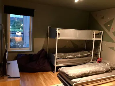 a bedroom with two bunk beds and a window at Pen leilighet i Trondheim in Trondheim