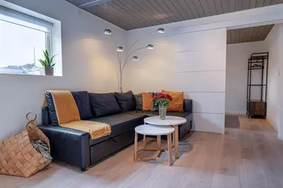 a living room with a black couch and a table at KS Apartment Modern & cozy flat 20 min from Bergen centre in Espeland