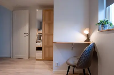 a room with a table and a chair and a hallway at KS Apartment Modern & cozy flat 20 min from Bergen centre in Espeland