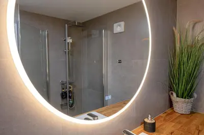 a mirror in a bathroom with a shower and a sink at KS Apartment Modern & cozy flat 20 min from Bergen centre in Espeland