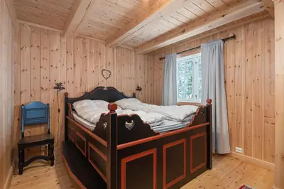 a bedroom with a bed in a room with wooden walls at Trysilfjell sør 825 in Trysil