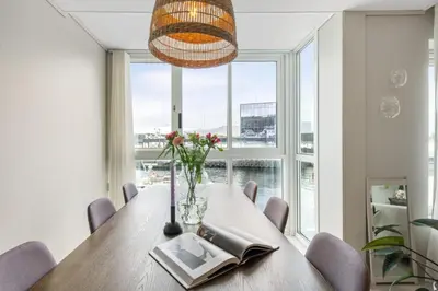 a dining room with a table and a large window at Florø Apartments Hotell in Florø
