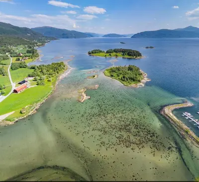 an aerial view of a group of islands in the water at Engbu in Vågbø
