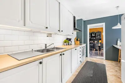 a kitchen with white cabinets and a sink at Engbu in Vågbø