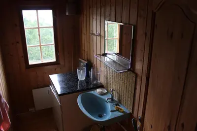 a bathroom with a sink and a mirror at Jonstølen by Norgesbooking - cabin at 1020 masl in Trondsgard