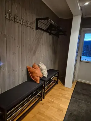 a black bench in a room with a wooden wall at Geilo Hytter & Camping in Geilo