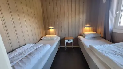 two beds in a room with two lights on at Geilo Hytter & Camping in Geilo