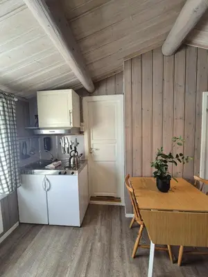 a kitchen with a table and a white refrigerator at Geilo Hytter & Camping in Geilo
