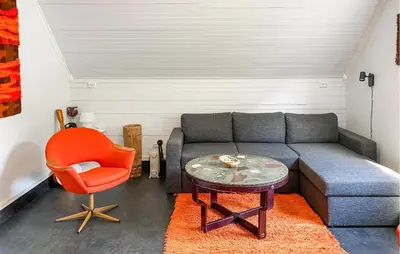 a living room with a couch and a orange chair at Cozy Home In Austefjorden With Wifi in Austefjorden