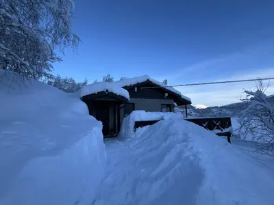 a pile of snow in front of a house at Cozy cabin with a view in Kvamseter