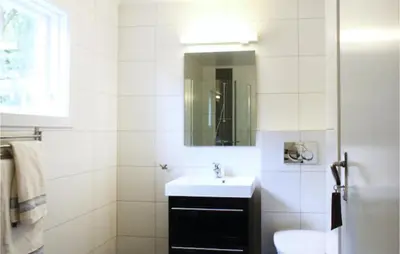 a white bathroom with a sink and a mirror at 4 Bedroom Nice Home In Eidfjord in Eidfjord