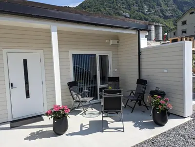 a patio with chairs and a table with flowers at Flotun in Stryn