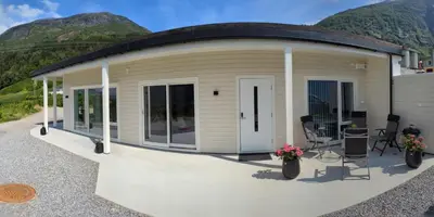 a mobile home with a circular roof with mountains in the background at Flotun in Stryn