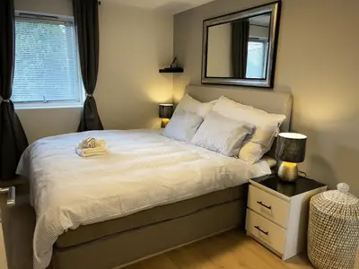 a bedroom with a bed with a mirror on the wall at Apartment Lagunen with Terrace, Grill and Free Parking in Bergen