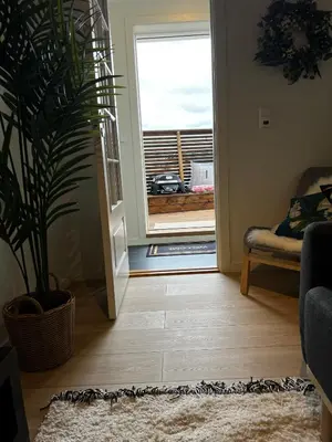 a living room with a door leading to a balcony at Apartment Lagunen with Terrace, Grill and Free Parking in Bergen