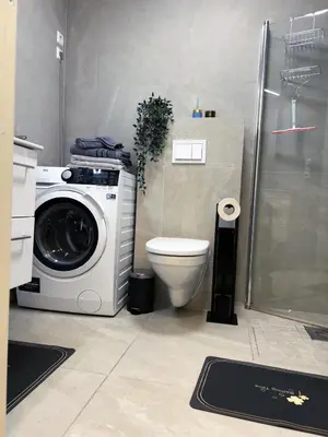 a bathroom with a washing machine and a toilet at Apartment Lagunen with Terrace, Grill and Free Parking in Bergen