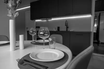a table with a plate and two wine glasses on it at Huset på Plassen in Sogndal