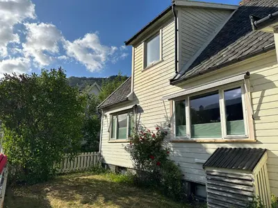 a white house with a window and a fence at Huset på Plassen in Sogndal