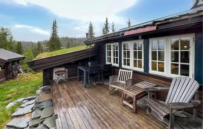 a house with a deck with a table and chairs at Awesome Home In Aurdal With Sauna in Aurdal