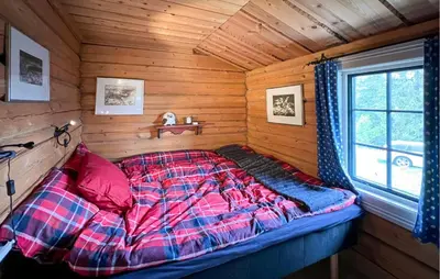 a bed in a log cabin with a window at Awesome Home In Aurdal With Sauna in Aurdal