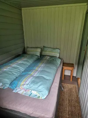a bed in the corner of a room at Hytta på Kvia, Rognestøyldalen - Sæbø in Sæbø