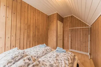two beds in a room with wooden walls at Toppleilighet i sentrum av Lillehammer in Lillehammer