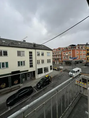 two cars parked in a parking lot next to buildings at Charming 3-Bedroom Apartment in the Heart of Kristiansund in Kristiansund