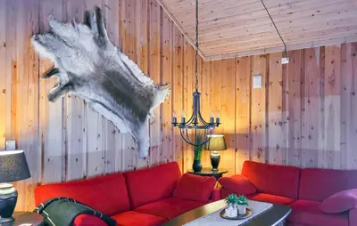 a living room with a red couch and wooden walls at Feriehus-Bjørkedal in Folkestad