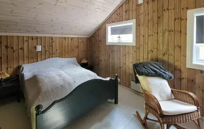 a bedroom with a bed and a chair at Feriehus-Bjørkedal in Folkestad