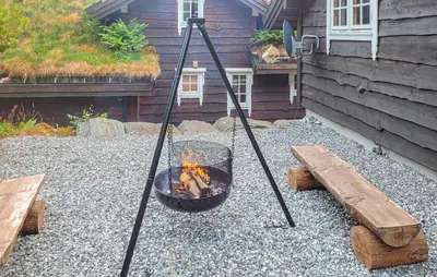 a fire pit and a bench on a gravel patio at Feriehus-Bjørkedal in Folkestad