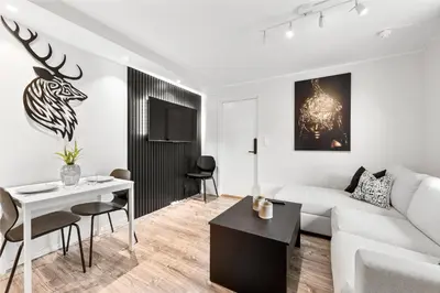 a living room with a white couch and a table at Pergola - Free parking - 5 min walk to facilities in Bergen