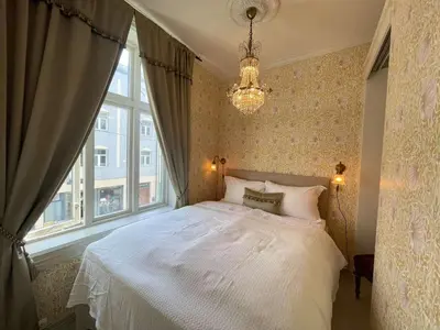 a bedroom with a white bed and a window at Jugend 1903 in Ålesund
