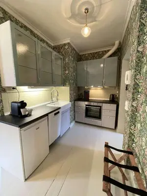a kitchen with gray cabinets and a white counter top at Jugend 1903 in Ålesund